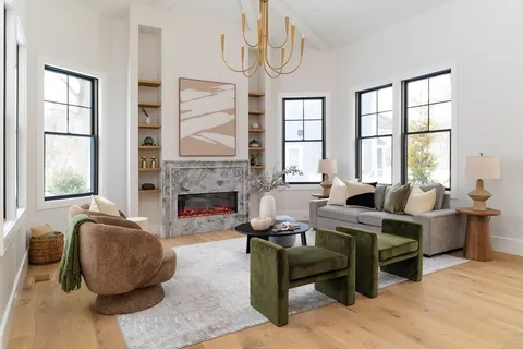 a living room with furniture a fireplace and windows