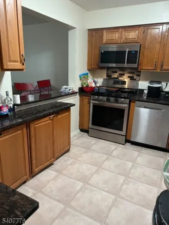 a kitchen with stainless steel appliances a stove a microwave and a sink