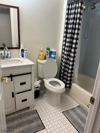 a bathroom with a sink a toilet a mirror and shower