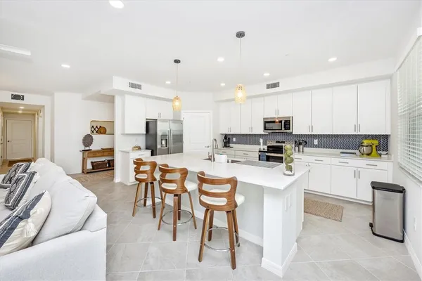 a kitchen with stainless steel appliances kitchen island granite countertop a refrigerator and microwave