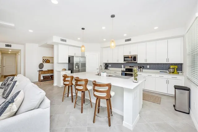 a kitchen with stainless steel appliances kitchen island granite countertop a refrigerator and microwave