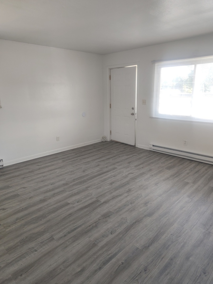 1039 Sheridan Road, Unit 3 Winthrop Harbor, IL 60096 - Photo 3 of 9 an empty room with wooden floor and windows