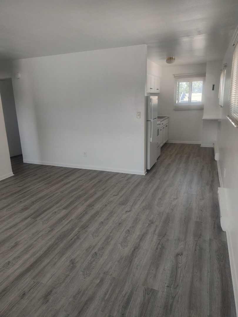1039 Sheridan Road, Unit 3 Winthrop Harbor, IL 60096 - Photo 4 of 9 an empty room with wooden floor and windows