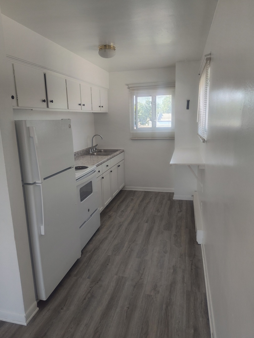 1039 Sheridan Road, Unit 3 Winthrop Harbor, IL 60096 - Photo 5 of 9 a kitchen with white cabinets and white appliances