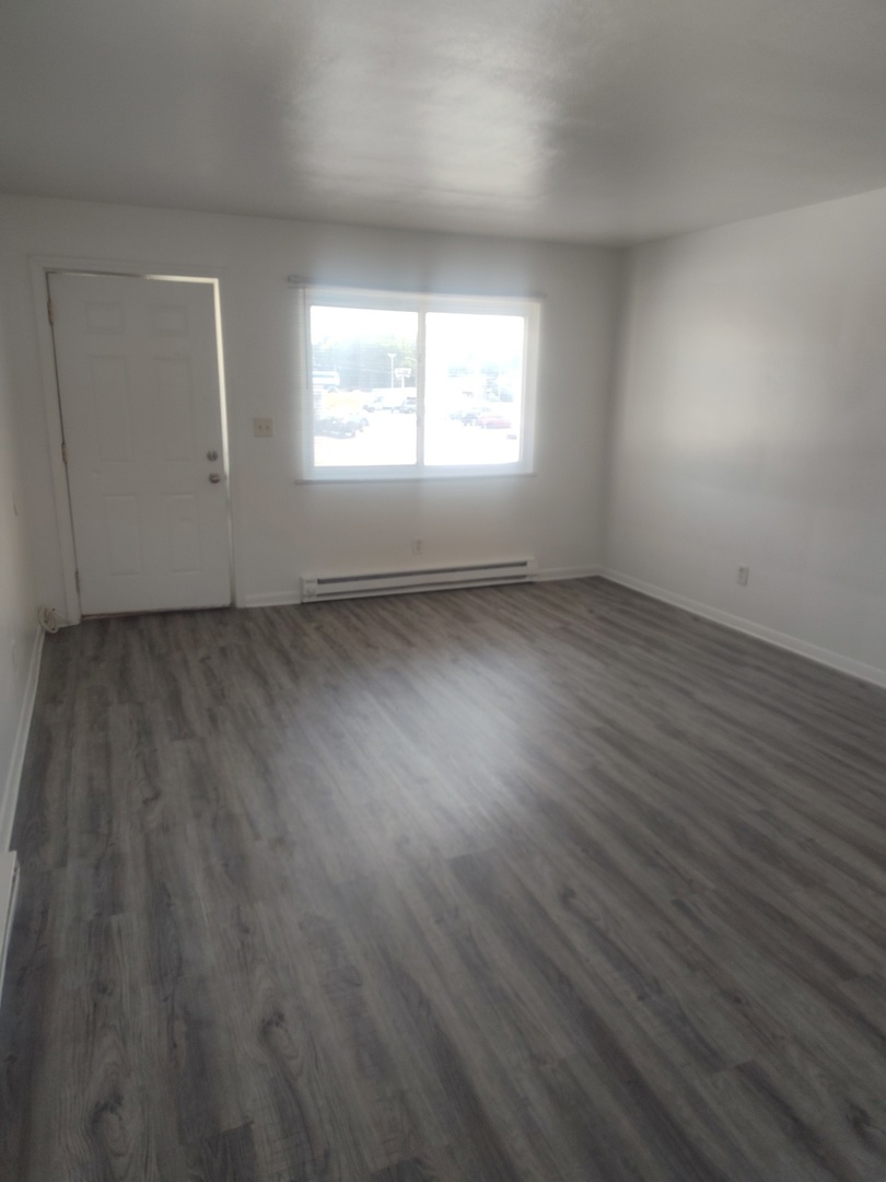 1039 Sheridan Road, Unit 3 Winthrop Harbor, IL 60096 - Photo 8 of 9 an empty room with wooden floor and windows