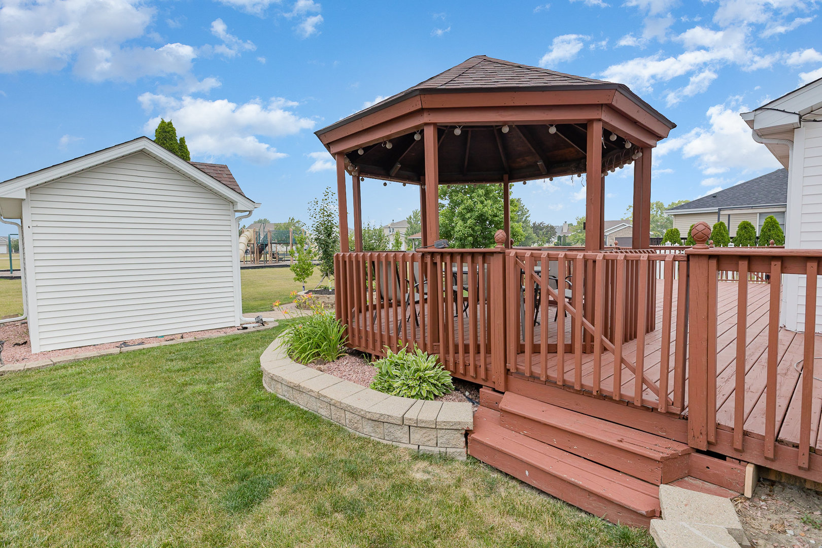 1560 Mallards Cove Beecher, IL 60401 - Photo 38 of 43 a view of a deck with a table and chairs under an umbrella with wooden fence