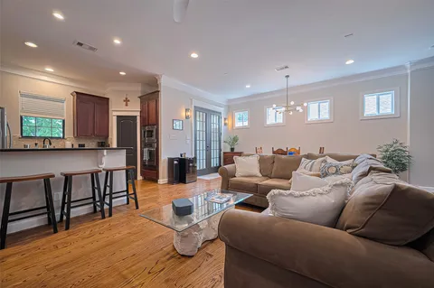 a living room with furniture wooden floor and kitchen view