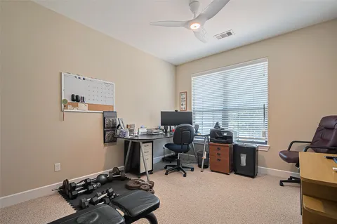 a view of a workspace with furniture and a window
