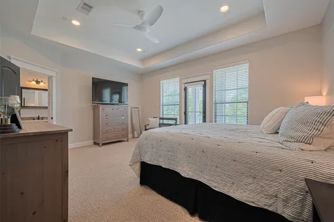 a spacious bedroom with a large bed and a flat tv screen on dresser