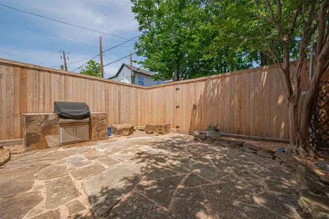 a view of a backyard with table and chairs and a large tree