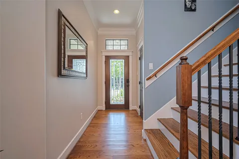 a view of a hallway with wooden floor and staircase