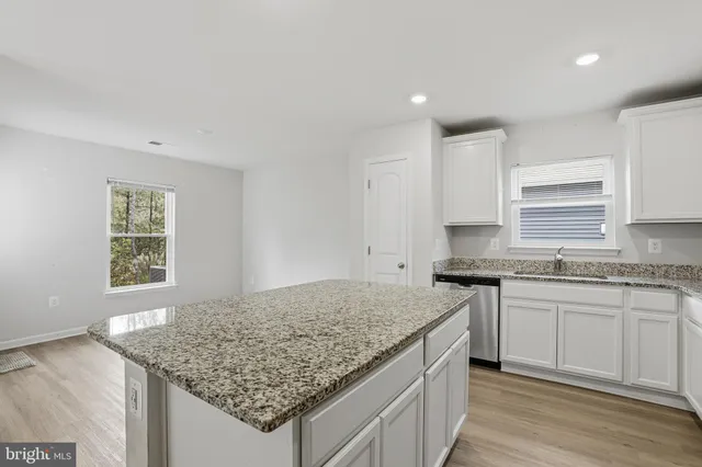 a kitchen with stainless steel appliances granite countertop a sink stove and cabinets