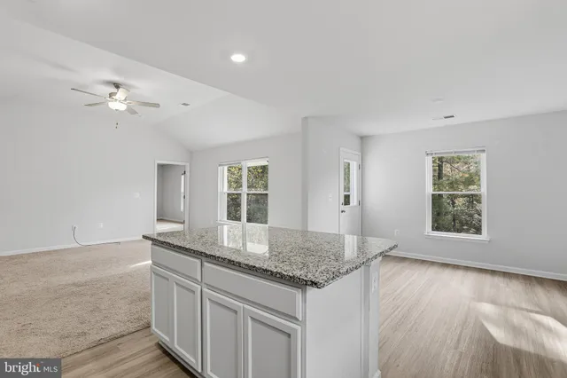 a kitchen with granite countertop a sink and dishwasher with wooden floor