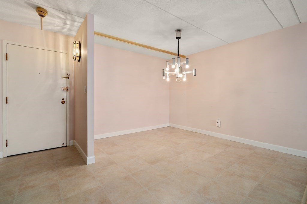 1550 Worcester Road, Unit 402 Framingham, MA 01702 - Photo 13 of 32 an empty room with chandelier and windows