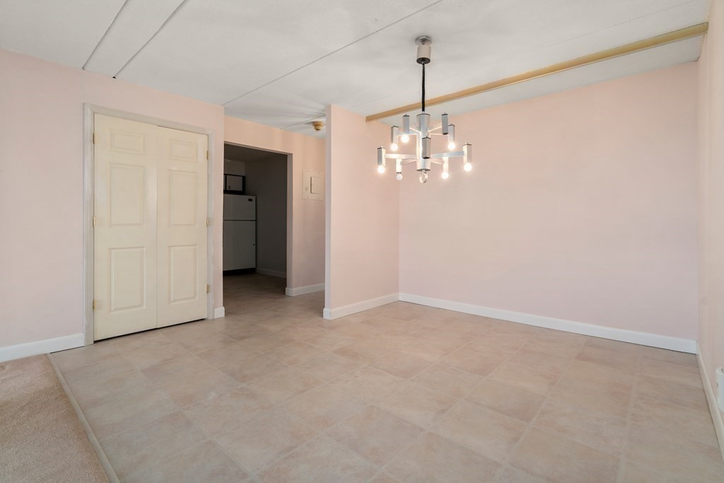 1550 Worcester Road, Unit 402 Framingham, MA 01702 - Photo 14 of 32 an empty room with chandelier fan and refrigerator