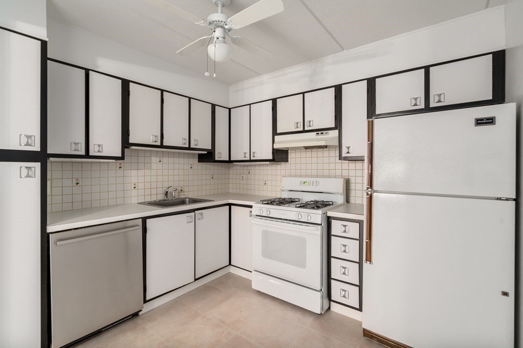 1550 Worcester Road, Unit 402 Framingham, MA 01702 - Photo 7 of 32 a kitchen with stainless steel appliances a refrigerator sink and cabinets