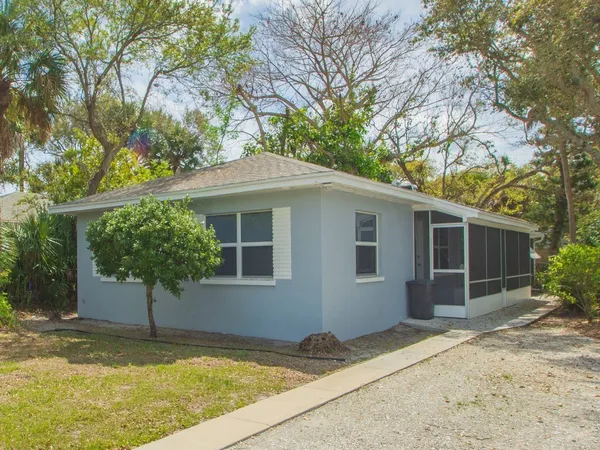 a view of a house with a yard and potted plants