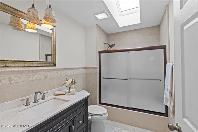 a bedroom with a bed and dresser with mirror