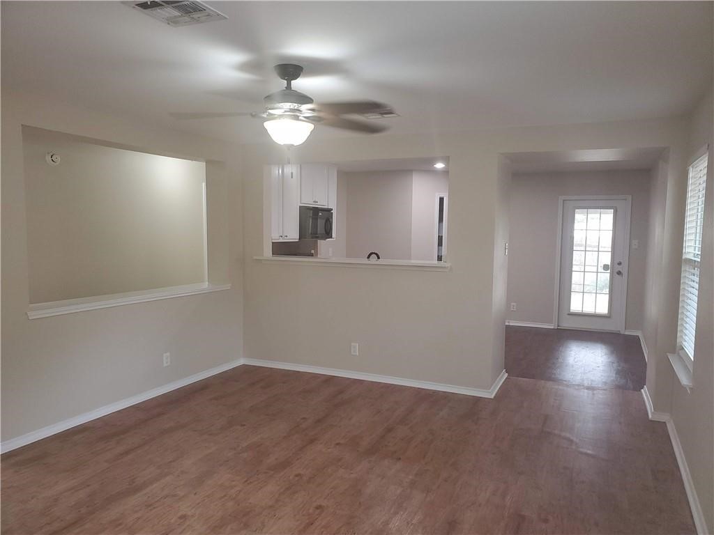 551 New Country Road Kyle, TX 78640 - Photo 3 of 34 a view of an empty room with wooden floor and a window