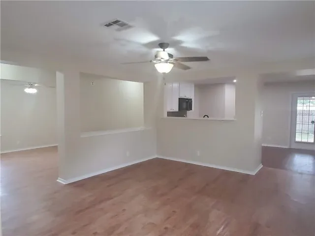a view of a room with a ceiling fan window and a ceiling fan