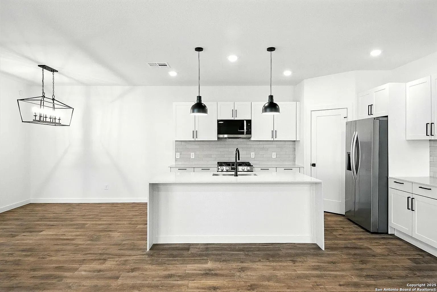 1809 North Peach Creek Drive, Unit 3C Dayton, TX 77535 - Photo 5 of 23 a kitchen with kitchen island stainless steel appliances a refrigerator a stove top oven and a center island