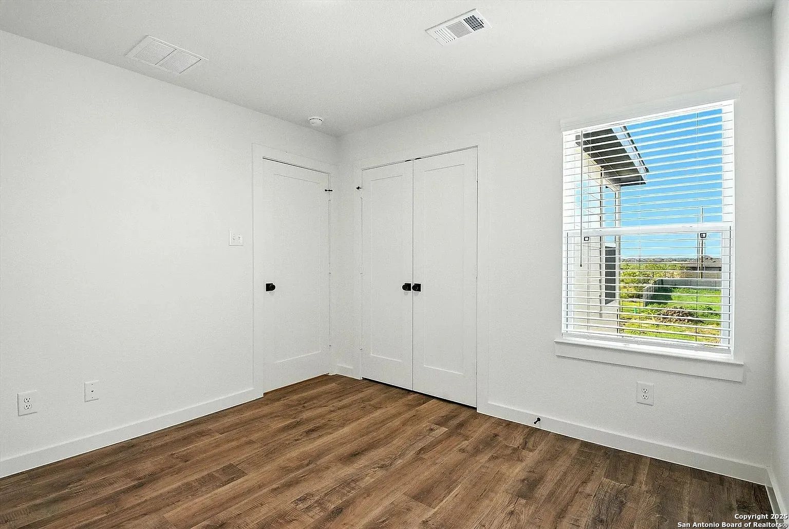 1809 North Peach Creek Drive, Unit 3C Dayton, TX 77535 - Photo 9 of 23 a view of an empty room with wooden floor and a window