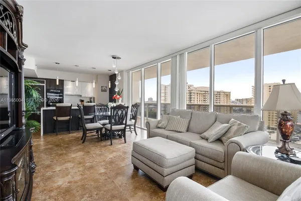 a living room with furniture kitchen view and a large window