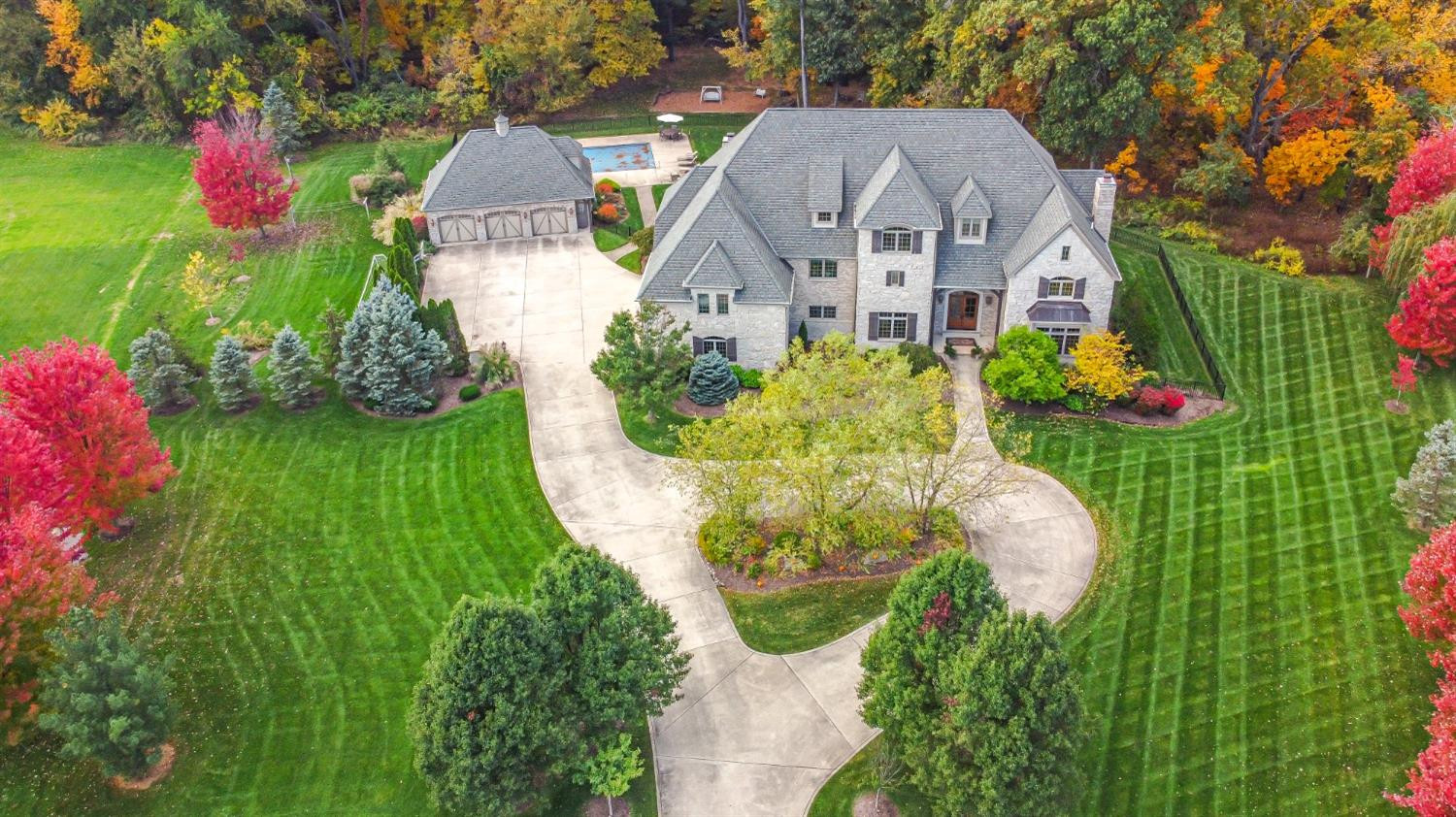 a aerial view of a house with a big yard and large trees