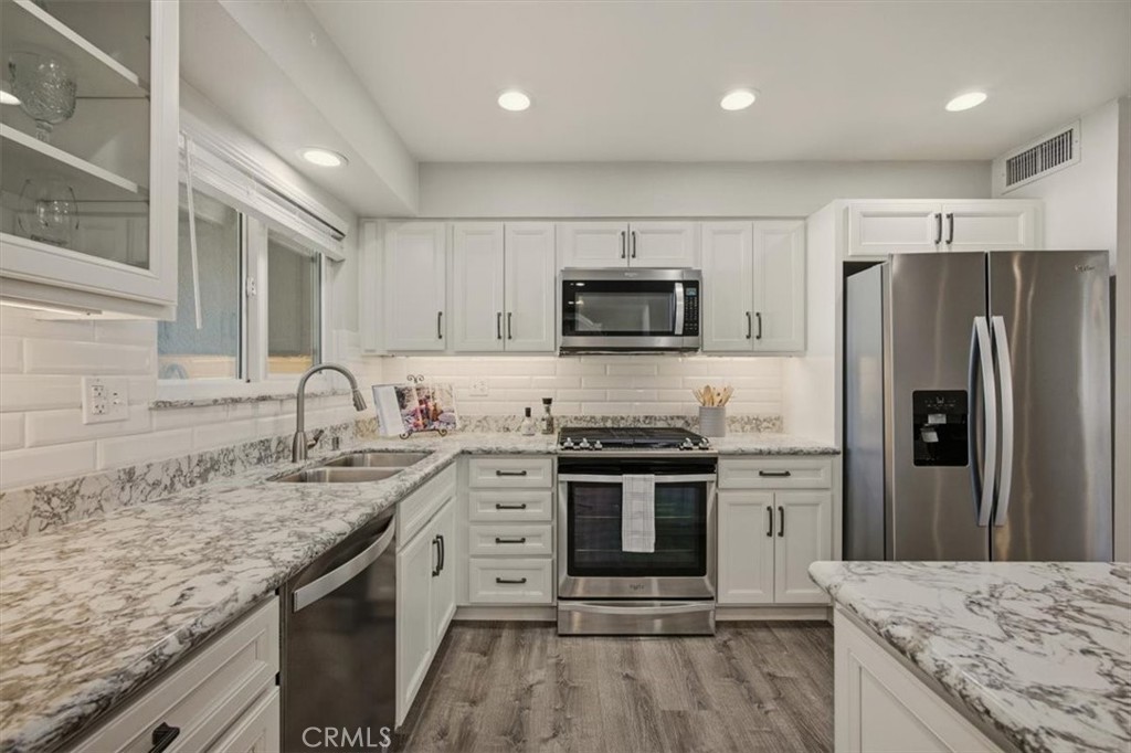 29326 Carmel Road Menifee, CA 92586 - Photo 18 of 44 a kitchen with stainless steel appliances granite countertop a stove top oven a sink and a refrigerator