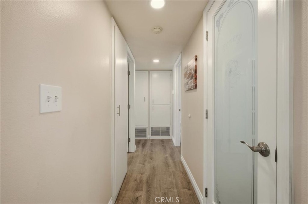 29326 Carmel Road Menifee, CA 92586 - Photo 23 of 44 a view of a hallway with wooden floor and a bathroom