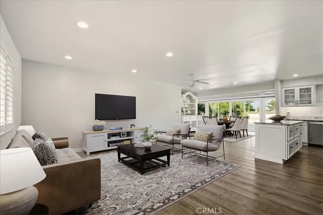 a living room with furniture flat screen tv and wooden floor