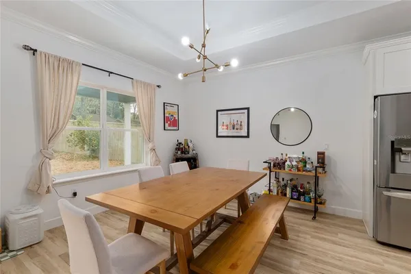 a kitchen with kitchen island a stove a refrigerator a sink dishwasher and white cabinets with wooden floor