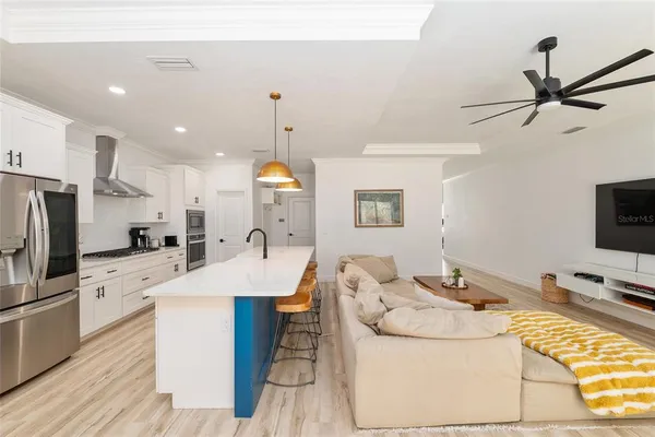 a kitchen with stainless steel appliances white cabinets a stove a sink and a refrigerator