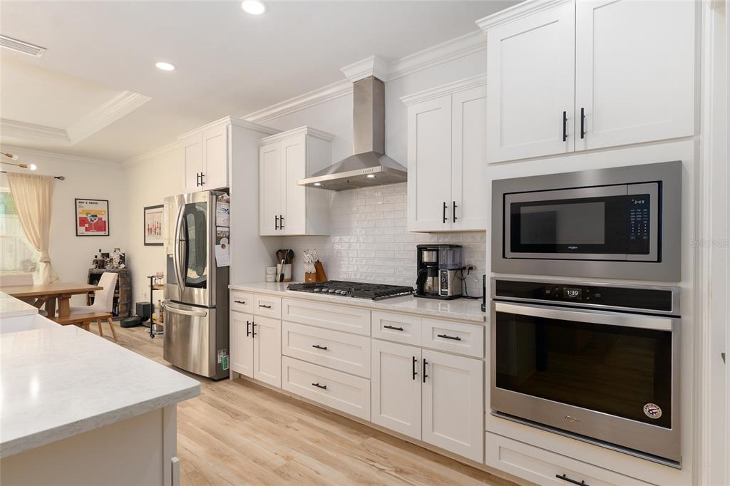 1759 Southwest 67th Circle Gainesville, FL 32607 - Photo 25 of 66 a kitchen with stainless steel appliances white cabinets a stove a sink and a refrigerator
