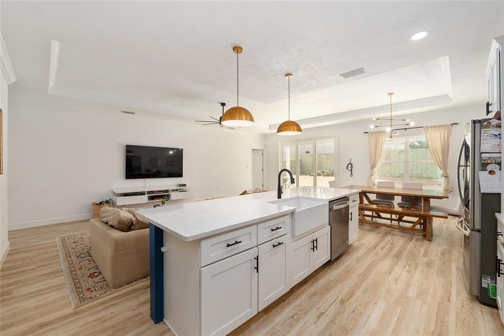 1759 Southwest 67th Circle Gainesville, FL 32607 - Photo 29 of 66 a large white kitchen with a stove a sink a refrigerator and a wooden floor