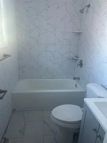 a bathroom with a toilet and a bath tub