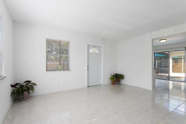 an empty room with window and a ceiling fan