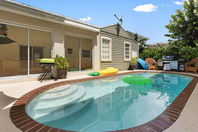 a view of a house with swimming pool and sitting area