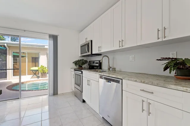 a kitchen with granite countertop white cabinets and a stove