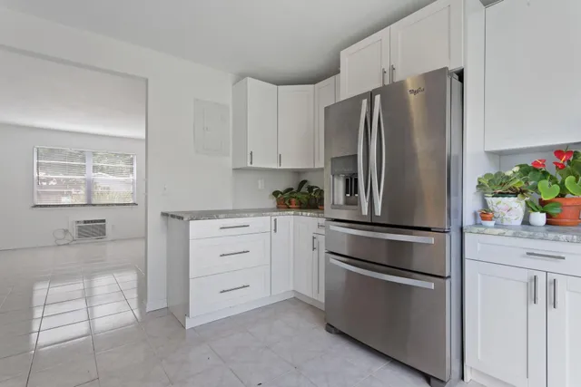 a kitchen with cabinets stainless steel appliances and a window