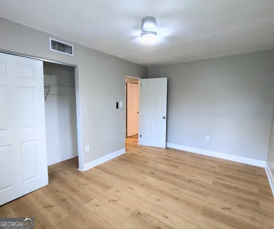 a view of empty room with wooden floor
