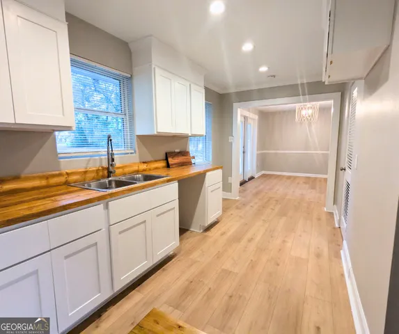 a kitchen with granite countertop a sink window and cabinets