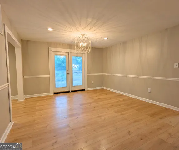 an empty room with wooden floor and natural light