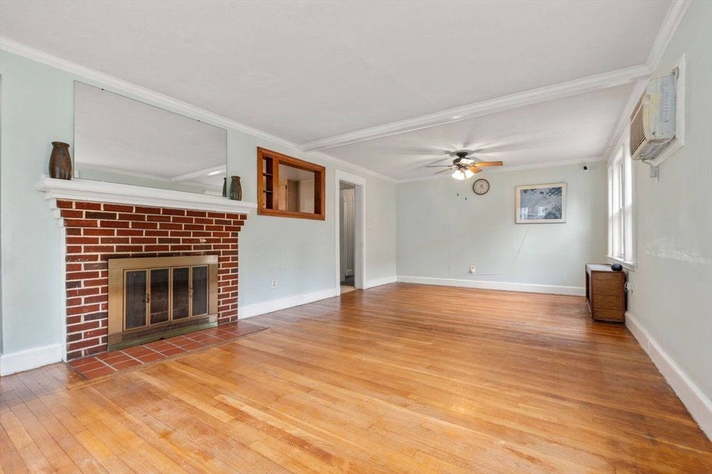 15 Atlantis Street Boston, MA 02132 - Photo 3 of 25 a view of empty room with wooden floor and fireplace