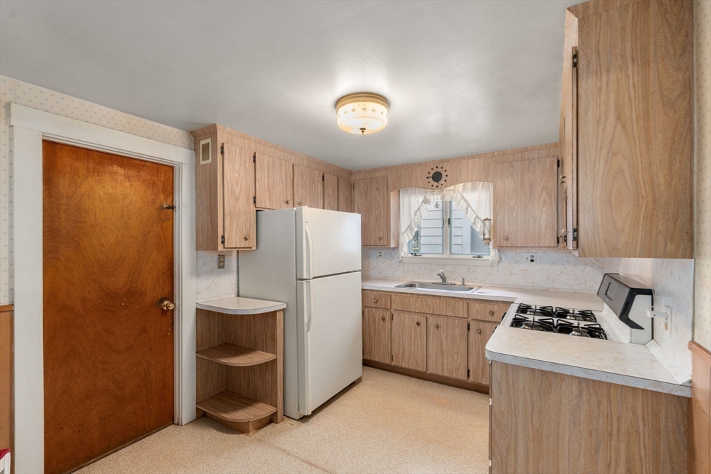 15 Atlantis Street Boston, MA 02132 - Photo 5 of 25 a kitchen with a refrigerator a sink and cabinets