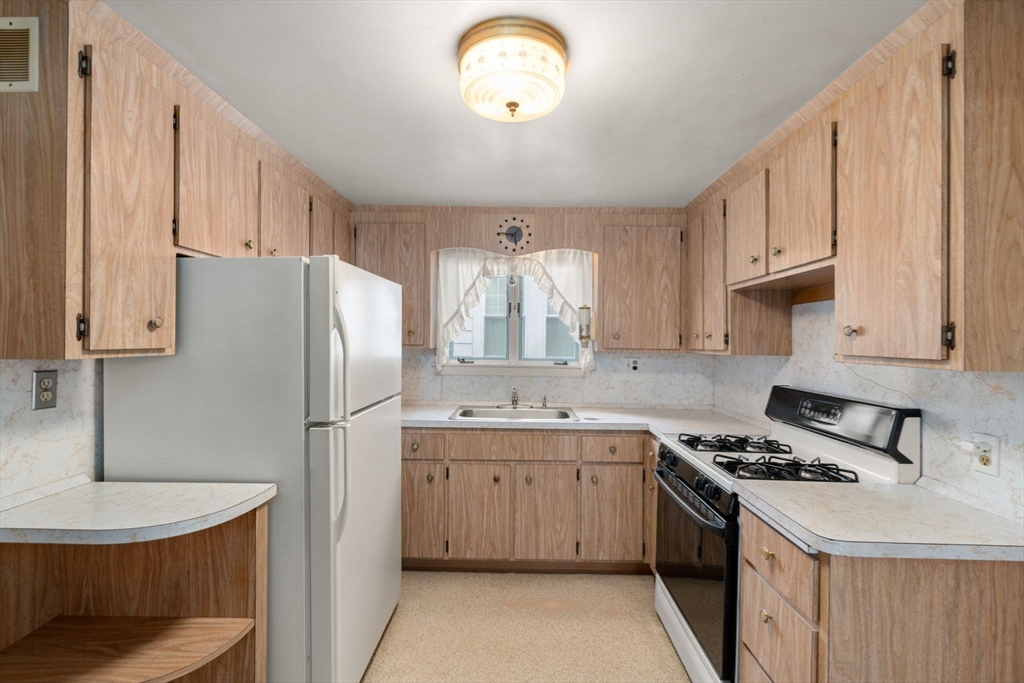 15 Atlantis Street Boston, MA 02132 - Photo 7 of 25 a kitchen with stainless steel appliances granite countertop a sink stove and refrigerator