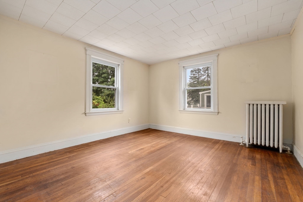 15 Atlantis Street Boston, MA 02132 - Photo 9 of 25 an empty room with wooden floor and windows