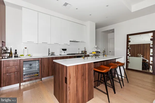a kitchen with stainless steel appliances granite countertop a table chairs sink and cabinets