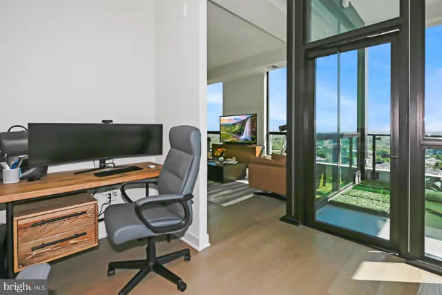 a view of a workspace with furniture and a window