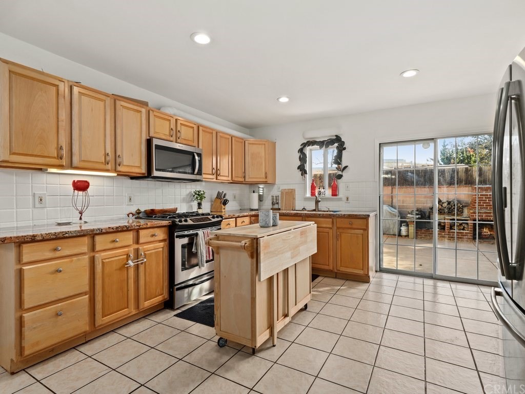 7356 Leescott Avenue Van Nuys, CA 91406 - Photo 16 of 31 a kitchen with stainless steel appliances granite countertop a stove top oven a sink a counter top space and cabinets